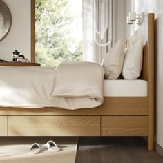 a bed with pillows and white slippers on top of it next to a mirror