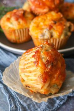 several muffins with cheese and meat are on a plate