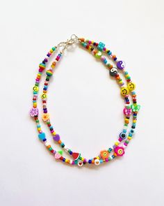 multicolored beaded necklace with smiley faces and hearts on the front, hanging from a silver chain