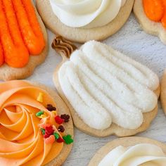 some cookies with frosting and candy on top of each other in the shape of carrots