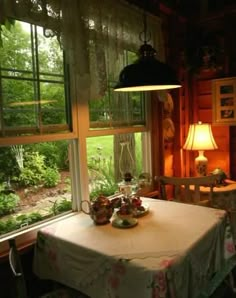 a dining room with a table, chairs and lamp in front of a large window