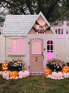 a pink halloween house with pumpkins and flowers