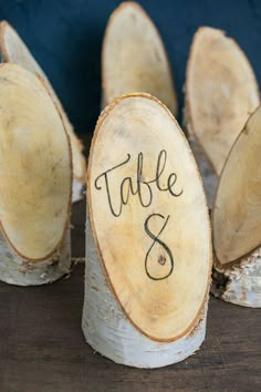 wood slices with the word table 8 written on them in cursive writing, placed next to each other