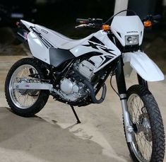 a white dirt bike parked on top of a parking lot