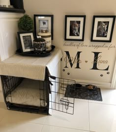 a dog crate sitting next to a wall with pictures on it