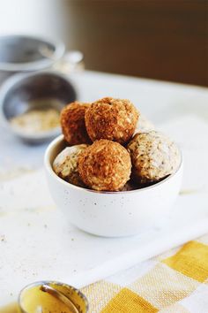 a white bowl filled with oatmeal balls on top of a yellow and white checkered table cloth