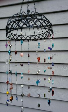 a wind chime hanging from the side of a house with lots of beads on it