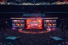 an aerial view of a concert venue with large screens on the stage and people in the audience