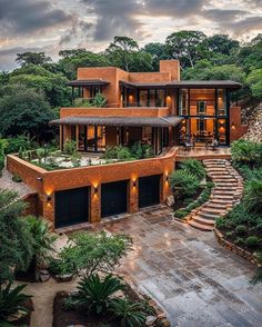 an aerial view of a house in the middle of trees and bushes, with stairs leading up to it