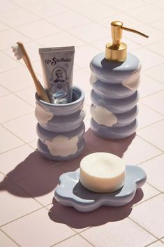 a soap dispenser and toothbrush holder on a tiled floor