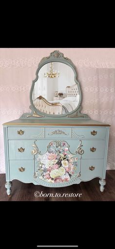 an antique dresser with flowers painted on it and a large mirror above the top drawer