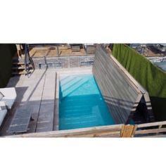 an above ground swimming pool in the middle of a building with stairs leading up to it