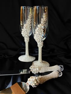 two champagne flutes are sitting next to each other on a black tableclothed surface