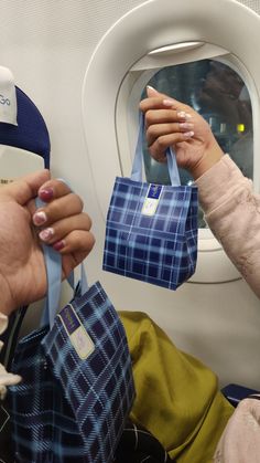 two people holding onto bags on an airplane