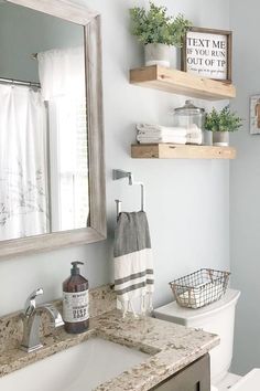 a bathroom with two wooden shelves above the toilet and a white sink in front of it