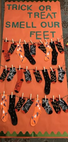 a sign that says trick or treat smell our feet with socks hanging from clothes pins