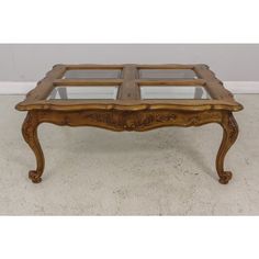 an antique coffee table with glass top