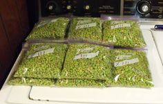 several bags of peas sitting on top of a dryer in front of an appliance