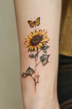 a sunflower with two butterflies on it's side tattoo by the artist in residence