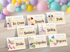 there are many place cards for children to put on the table with balloons in the background