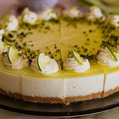 there is a cheesecake with green toppings on the cake platter, ready to be eaten