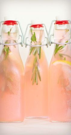 three bottles filled with pink liquid sitting next to each other