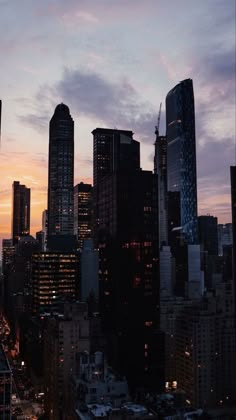 the city skyline is lit up at night, with skyscrapers in the foreground