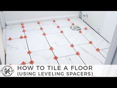 a bathroom with white tile and orange dots on the floor that are lined up in rows