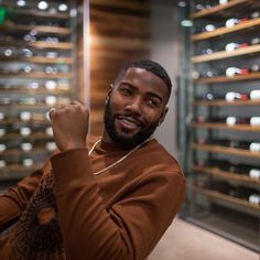 a man in a brown sweater is posing for a photo