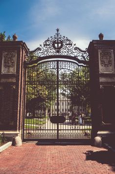 an iron gate is open on a brick walkway