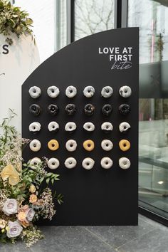 there are many donuts on display in front of the store's entrance window