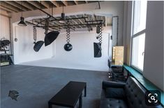 an empty room with black furniture and hanging lights