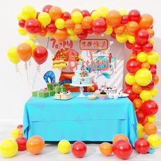 a blue table topped with cake and balloons