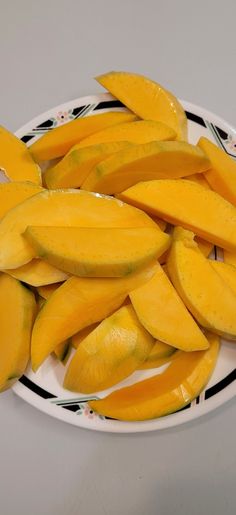 sliced mangoes on a white plate sitting on a table