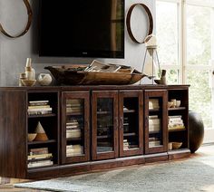 a living room with a large flat screen tv on top of a wooden entertainment center