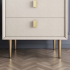 a white chest of drawers with gold handles