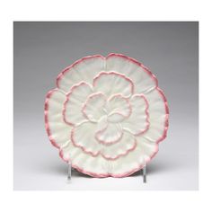 a white and pink plate with a flower on it