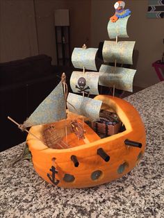 a pumpkin shaped like a pirate ship on top of a counter with other items in it