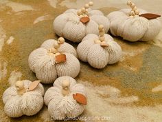 knitted pumpkins are sitting on the floor with leaves attached to them, all in white