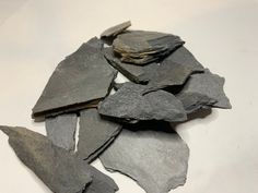 a pile of slate chips sitting on top of a white table