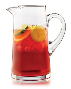 a pitcher filled with red liquid and orange slices