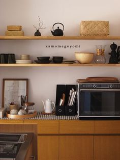 a microwave and toaster oven sitting on top of a wooden shelf in a kitchen