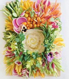 an arrangement of flowers and vegetables arranged in the shape of a circle