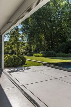 an open patio with a pool and trees in the backgroung area is shown