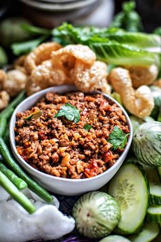 a bowl filled with meat surrounded by vegetables