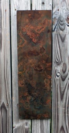 an old rusted metal plate on a wooden fence