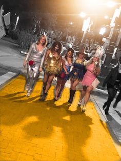 four women dressed in costumes walking down the street