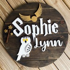 a wooden sign that says sophiie lynn with an owl and stars on it