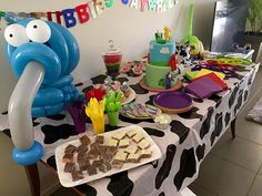 a table topped with lots of desserts and balloons in the shape of an elephant