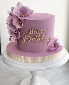 a purple birthday cake with flowers on top